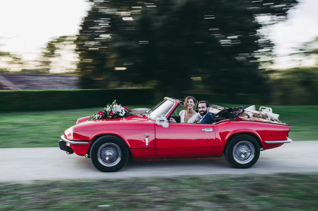 mariés heureux dans un joli cabriolet vintage