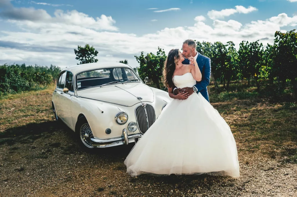 les mariés posent devant leur Jaguar vintage
