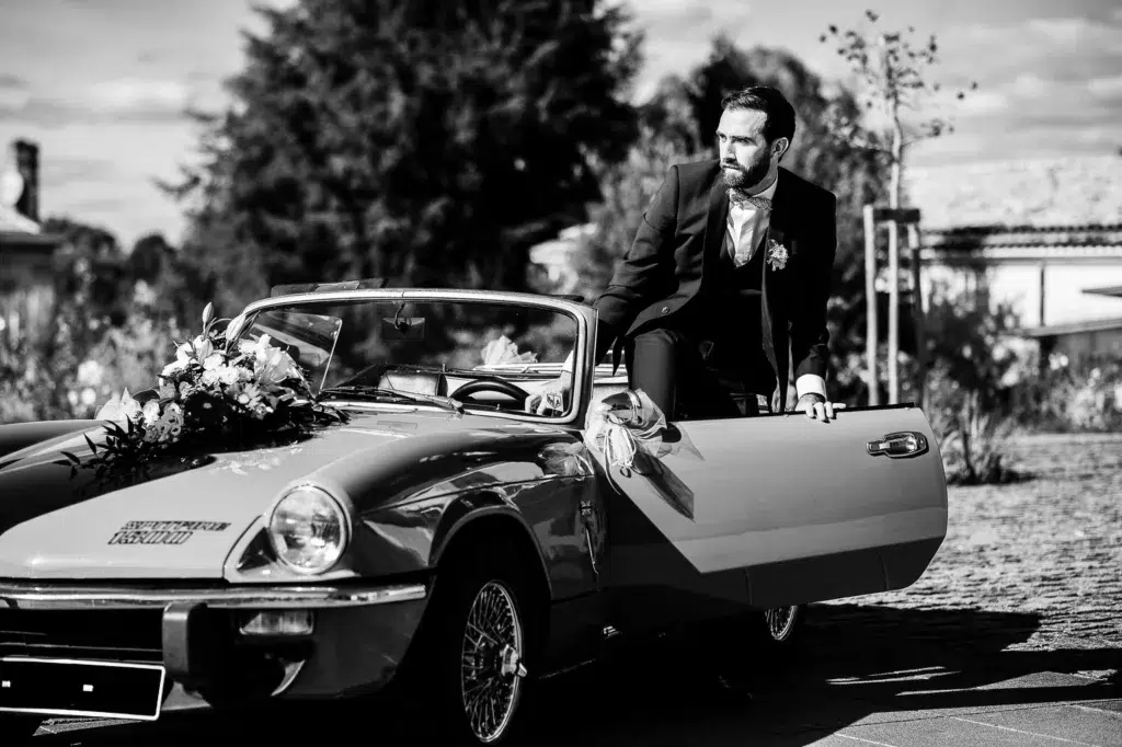 le marié descend de son cabriolet vintage
