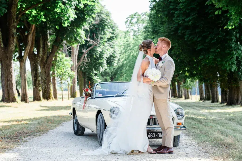 les mariés devant leur joli cabriolet vintage
